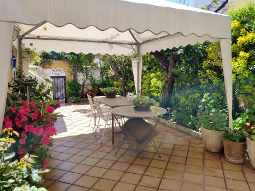 patio ze stołem i białą pergolą w obiekcie Chalet en Valle del Tietar w mieście Lanzahita