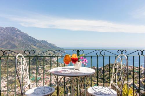 a table with a vase of flowers on a balcony at Via Col Vento in Ravello