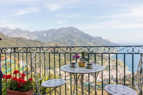 a table and chairs on a balcony with a view of the mountains at Via Col Vento in Ravello