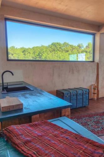 a room with a sink and a window with two suitcases at Elite apartment in Limenaria