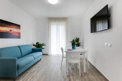 a living room with a blue couch and a table at Elegance Suite Apartments - Siroli Collection in Cervia