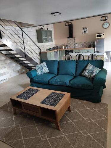 ein Wohnzimmer mit einem blauen Sofa und einem Couchtisch in der Unterkunft Gîte Les Rouffy in Saint-Mard-lès-Rouffy
