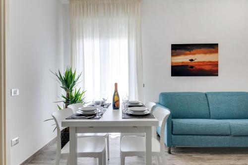 a dining room with a table and a blue couch at Elegance Suite Apartments - Siroli Collection in Cervia