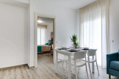 a white dining room with a table and chairs at Elegance Suite Apartments - Siroli Collection in Cervia