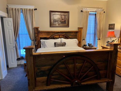 a bedroom with a wooden bed with a woodenokedokedokedoked at Historic Branson Hotel - Horseshoe Room with King Bed - Downtown - FREE TICKETS INCLUDED in Branson