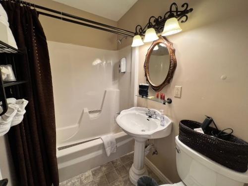 a bathroom with a sink and a toilet and a tub at Historic Branson Hotel - Notebook Room with Queen Bed - Downtown - FREE TICKETS INCLUDED in Branson
