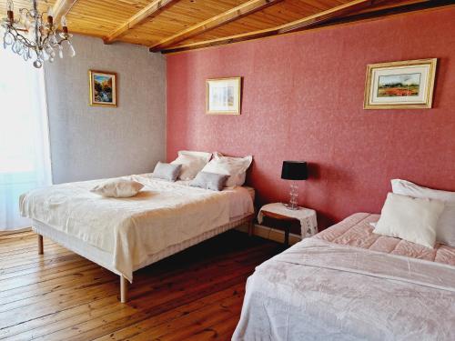 two beds in a room with red walls at Chez Sarah - L'Amaryllis in Javerlhac-et-la-Chapelle-Saint-Robert