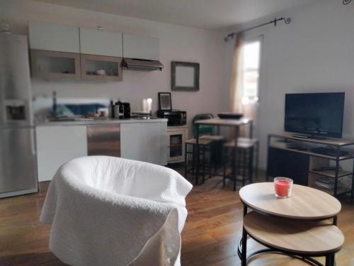 - un salon avec une chaise blanche et une table dans l'établissement Appartement coeur de Saint-Tropez, à Saint-Tropez