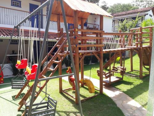 a wooden playground with a slide and swings at Hotel Ponta do Morro in Tiradentes
