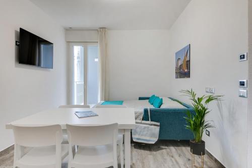 a white room with a table and chairs and a bed at Elegance Suite Apartments - Siroli Collection in Cervia