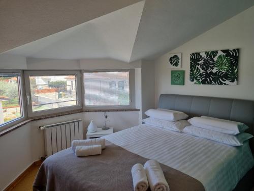una camera con un grande letto e due finestre di Apartma Katy a Umag (Umago)
