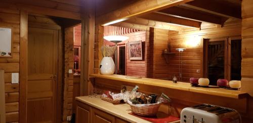 een keuken met houten wanden en een aanrecht met een wastafel bij Chalet Henri classé 3 étoiles aux Portes du Soleil in Montriond