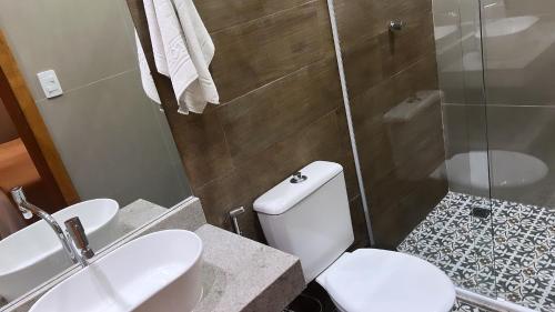 a bathroom with a toilet and a sink and a shower at Hotel Rio in Guarujá