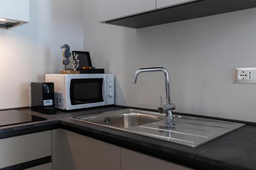 a kitchen with a sink and a microwave at Elegance Suite Apartments - Siroli Collection in Cervia
