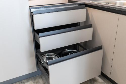 a kitchen with white drawers and a sink at Elegance Suite Apartments - Siroli Collection in Cervia