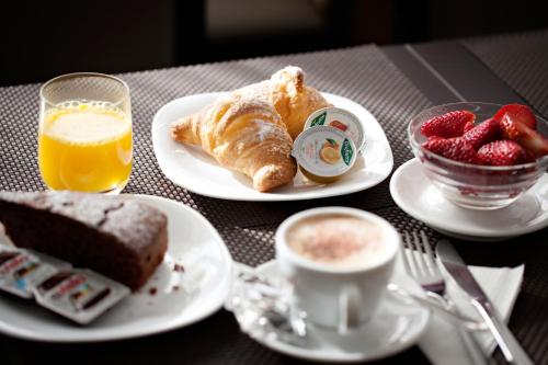 a table with two plates of food and a cup of coffee at Hotel Dei Fiori in Milan