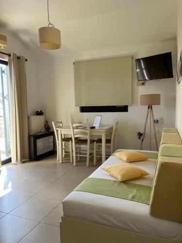 Schlafzimmer mit einem Bett und einem Tisch mit Stühlen in der Unterkunft Myrthe Apartments in Myrtos