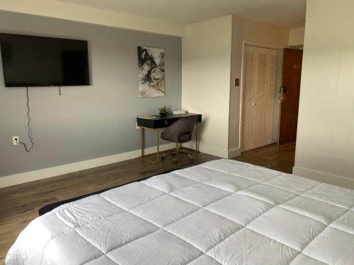 1 dormitorio con 1 cama blanca grande y escritorio en Sophisticated studio apartment in Gadsden, AL, en Gadsden
