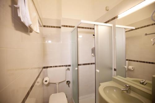 a bathroom with a shower and a toilet and a sink at Hotel Dei Fiori in Milan