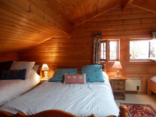 een slaapkamer met een bed in een blokhut bij Chalet Henri classé 3 étoiles aux Portes du Soleil in Montriond