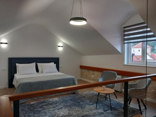 1 dormitorio con 1 cama, mesa y sillas en Hidden Heritage en Skradin