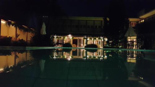 a house with lights in front of a pool at night at Don Quixote Pousada in Tiradentes