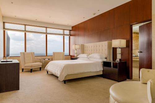 a bedroom with a bed and a desk and a chair at Sheraton Grand Panama in Panama City