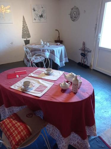 a room with a table with a red table cloth at les chambres du pont des chèvres in Commensacq