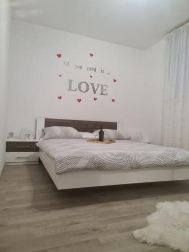 een slaapkamer met een bed met een liefdesbord aan de muur bij MANUELA in Senj