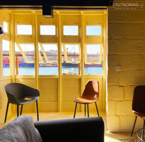 a room with three chairs in front of a window at Crew 2 Savynomad Harbour Residences wow Views in Cospicua