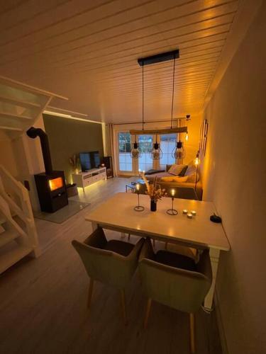 a room with a dining table and a living room at Nordseetraum - Ferienhaus Wolke in Friedrichskoog