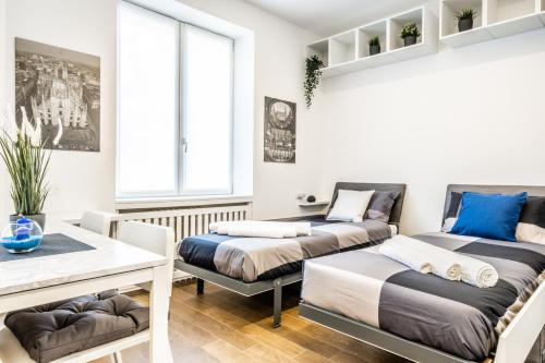 Habitación con 2 camas y mesa. en [City Life House-BLUE] San Siro & Duomo, en Milán