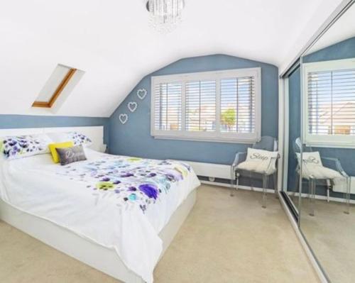 - une chambre avec un grand lit et 2 fenêtres dans l'établissement Empress Tree Cottage with large hot tub, à Poole