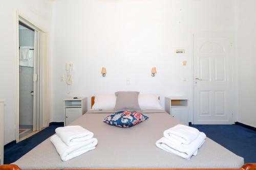 a bedroom with a large bed with towels on it at Hotel Hippocampus in Perdhika