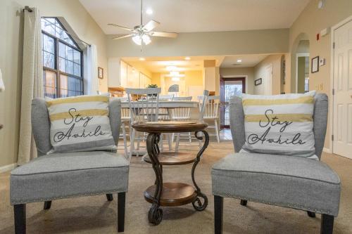 a living room with two chairs and a table at 2BR Penthouse Condo - 2 Pools - Close to the Strip - Stairs Required - FREE TICKETS INCLUDED - FHC-24 in Branson