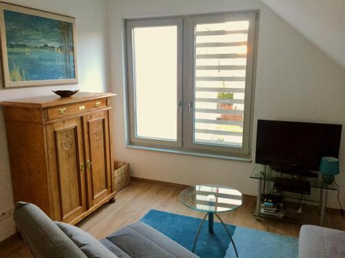 a living room with a couch and a tv at Ruhige 2-Zimmer Ferienwohnung FeWo Bodensee in Öhningen