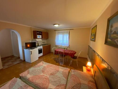 um quarto com uma cozinha e uma sala de estar em Hajnal Apartman em Hajdúszoboszló