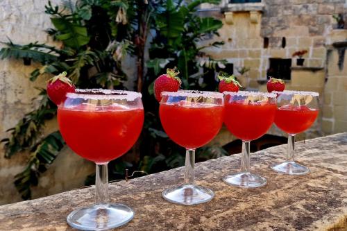 un grupo de cuatro copas de vino con fresas en ellas en Haven Farmhouse B&B, en Għarb