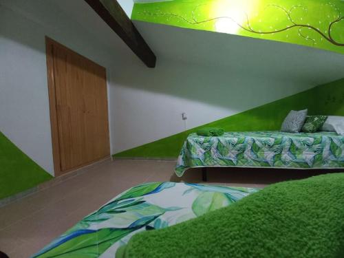 1 dormitorio con 2 camas y pared verde en El Laberinto, en Sotillo de la Adrada