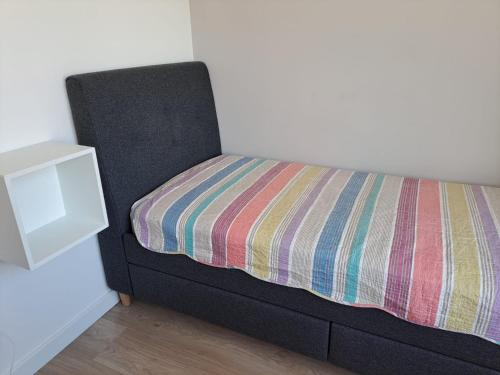 Una cama con una manta a rayas en una habitación en Oak apartment, en Riga
