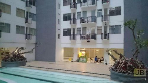 Un edificio con piscina enfrente. en Jarrdin Cihampelas C2218, en Bandung
