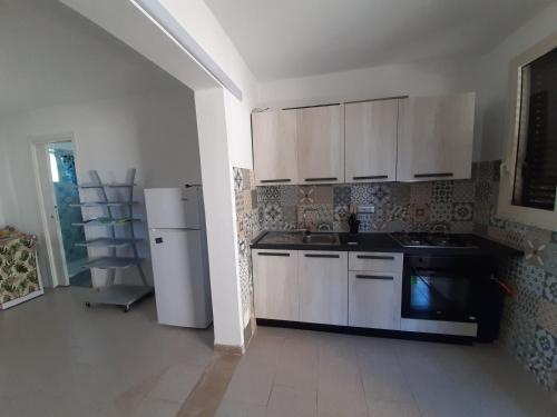 a kitchen with white cabinets and a white refrigerator at Casa De Santis - Roby e Fra al mare Cavallucci in Isola Capo Rizzuto