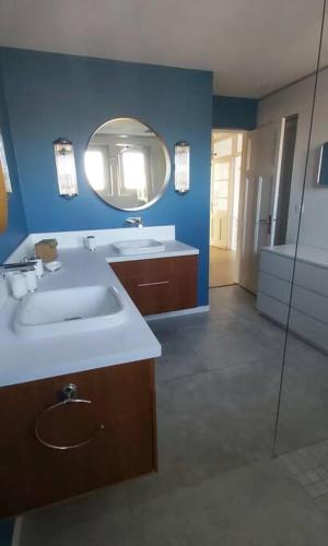 une salle de bain avec un lavabo et un miroir dans l'établissement La Maison Tchanquée jusqu'à 12 personnes Jacuzzi privé, à Gujan-Mestras