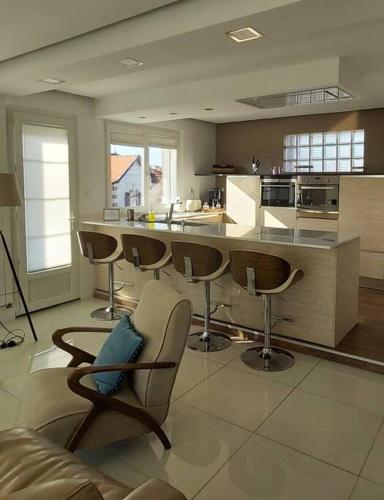 - une cuisine avec tabourets de bar et comptoir dans l'établissement La Maison Tchanquée jusqu'à 12 personnes Jacuzzi privé, à Gujan-Mestras