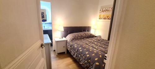 a small bedroom with a bed and a table with a lamp at SeaYouSoon Inn Cannes - Studios in Cannes