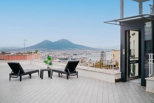 a balcony with two chairs and a table on a building at Vista Napoli Residence by Casa Napoletana in Naples