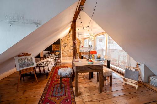 a living room with a table and chairs in a attic at Gästezimmer Plänke in Biel