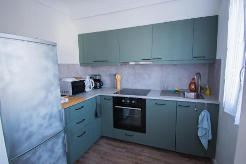 una cocina con armarios azules y fregadero en Beautiful Apartment 200m from Beach en Canet-en-Roussillon