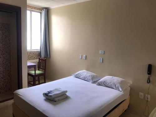 Un dormitorio con una cama con un teléfono. en Hotel BELCENTRO en Belém