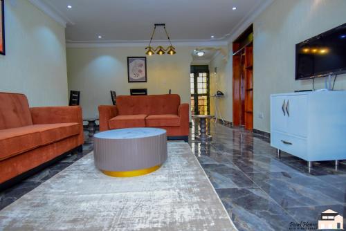 a living room with two couches and a coffee table at Elegant 2bedroom apartments close to city center in Kampala